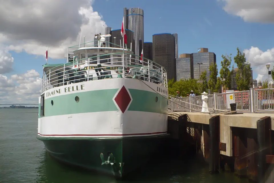 A Diamond Jack's hajója a Detroit folyó partján, háttérben a belváros felhőkarcolói