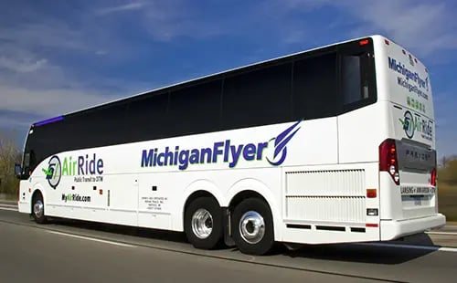 Fehér MichiganFlyer távolsági busz halad az autópályán