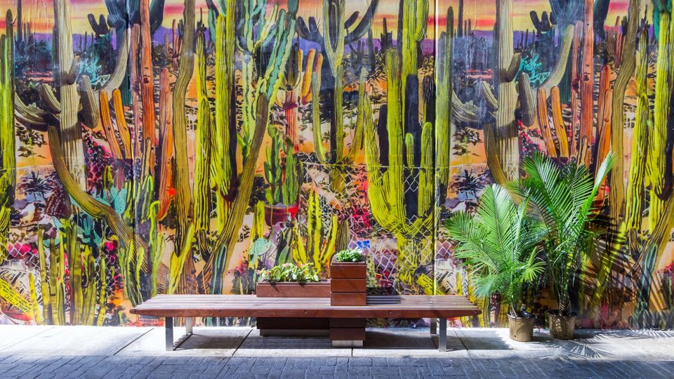 Colorful murals and cactus sculptures decorate the seating area in The Belt