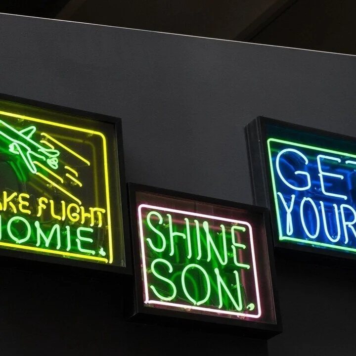 Neon signs light up the dark walls of The Belt alley at night